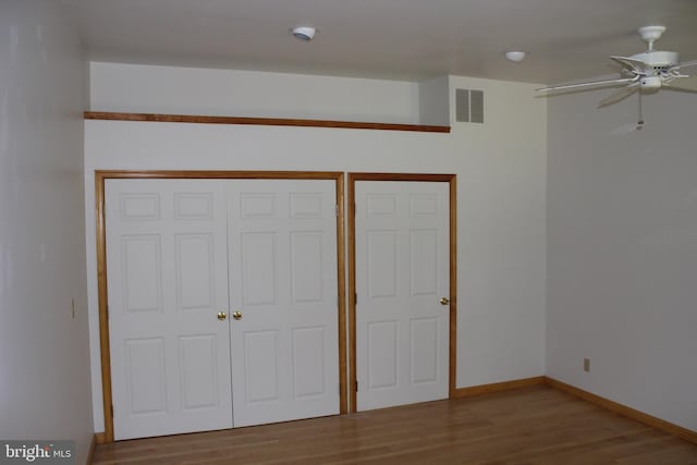 unfurnished bedroom with ceiling fan and hardwood / wood-style floors