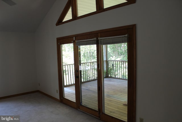 doorway to outside featuring carpet flooring and vaulted ceiling