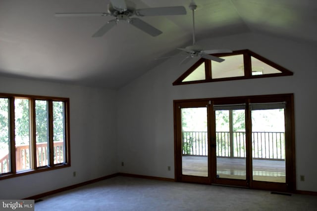 carpeted empty room featuring ceiling fan, plenty of natural light, and lofted ceiling