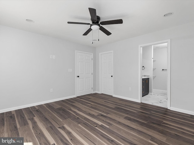 unfurnished bedroom with dark wood-type flooring, ensuite bath, and ceiling fan