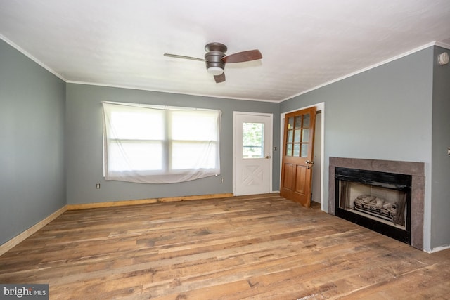 unfurnished living room with ceiling fan, ornamental molding, and wood-type flooring