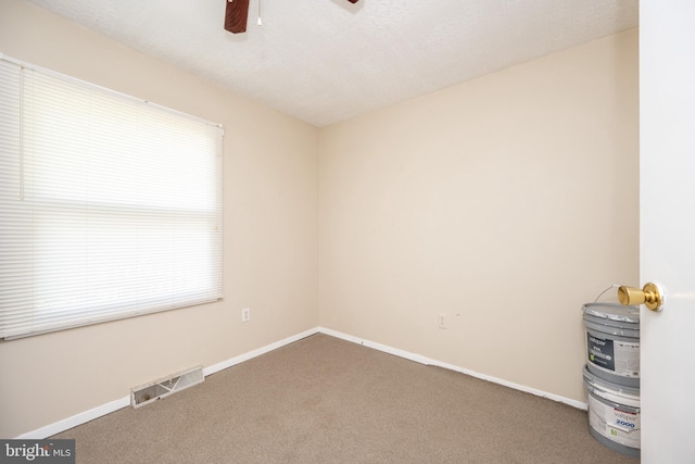 carpeted empty room with a textured ceiling and ceiling fan