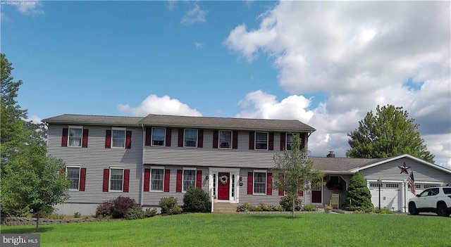 colonial inspired home featuring a garage and a front yard