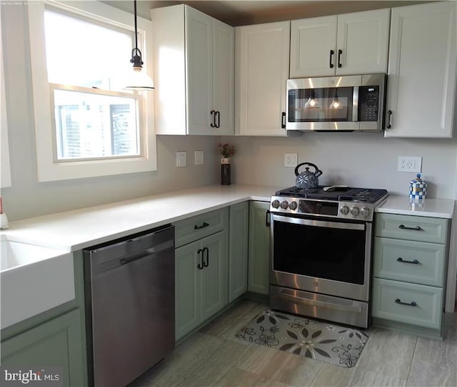 kitchen featuring green cabinetry, white cabinetry, stainless steel appliances, and light countertops