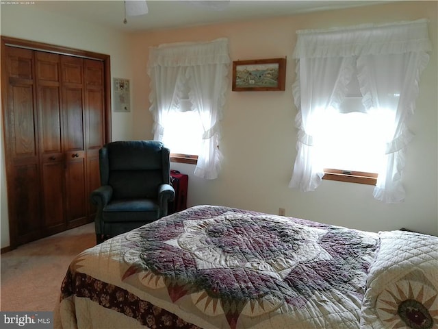 carpeted bedroom with ceiling fan and a closet