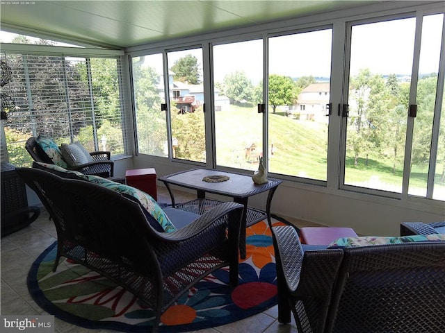 sunroom featuring lofted ceiling and a healthy amount of sunlight