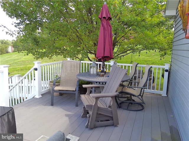 wooden terrace with a yard and outdoor dining space