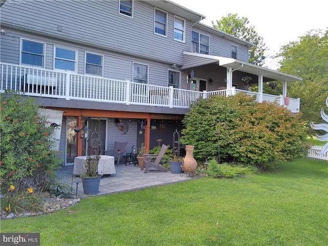 back of property with a lawn and a patio