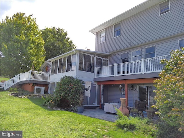 back of property with a patio, a sunroom, and a yard