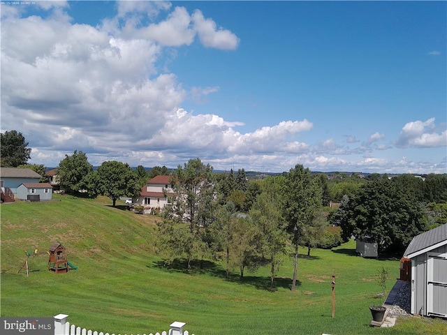 view of yard with fence and a playground