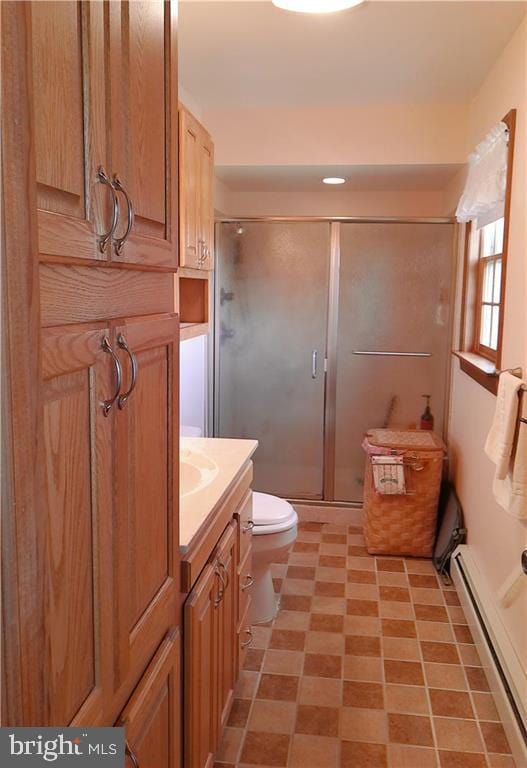 bathroom with baseboard heating, tile patterned flooring, vanity, toilet, and a shower with door