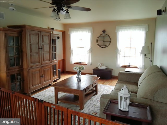 living room featuring light hardwood / wood-style flooring and ceiling fan