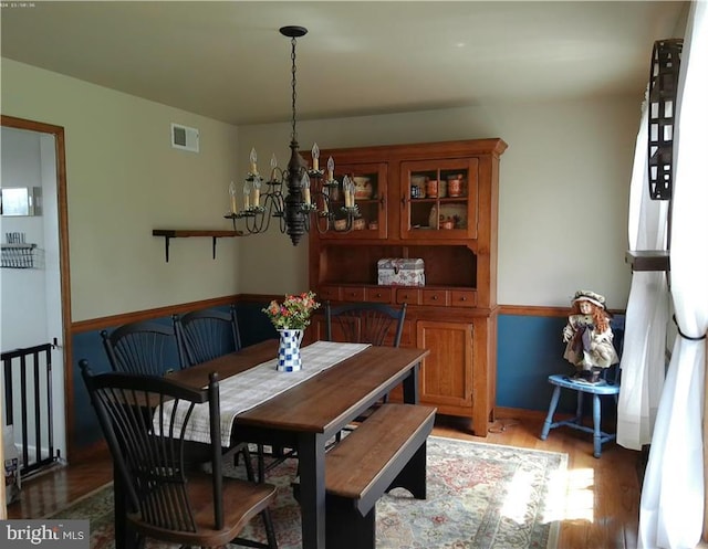 dining space featuring light wood-type flooring, visible vents, and an inviting chandelier