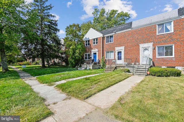 townhome / multi-family property featuring a front lawn