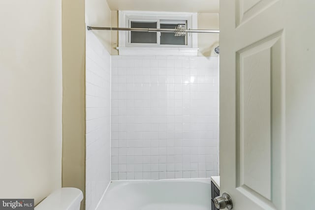 bathroom with tiled shower / bath and toilet