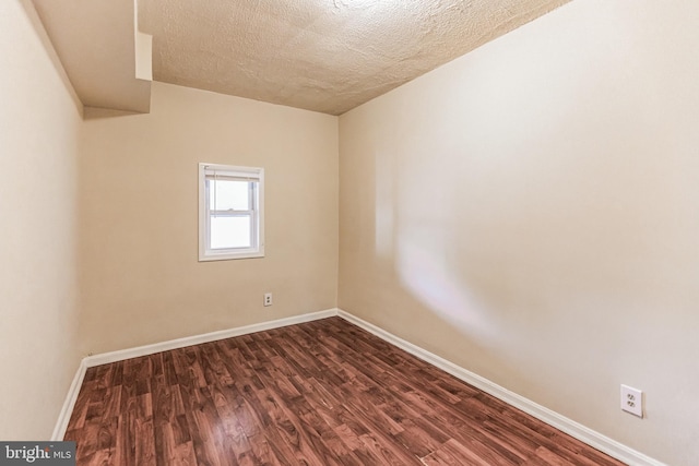 spare room with a textured ceiling and hardwood / wood-style floors