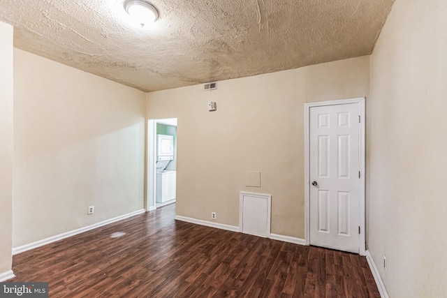 spare room featuring a textured ceiling, washer / clothes dryer, and wood-type flooring