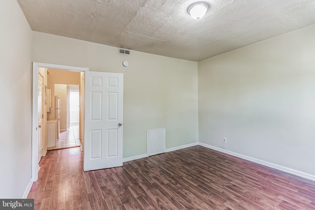 spare room featuring tile patterned flooring and a textured ceiling