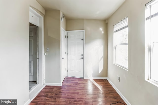 foyer entrance featuring baseboards and dark wood finished floors