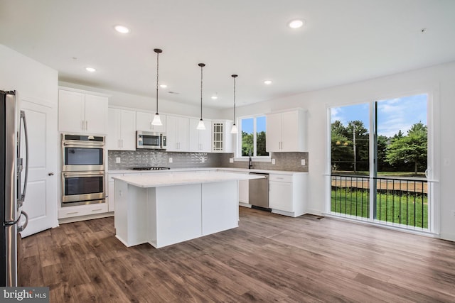 kitchen featuring appliances with stainless steel finishes, plenty of natural light, and wood-type flooring