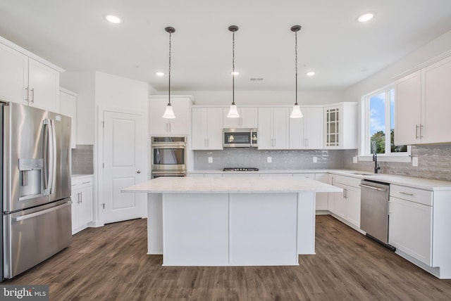 kitchen featuring a kitchen island, backsplash, dark hardwood / wood-style floors, and stainless steel appliances