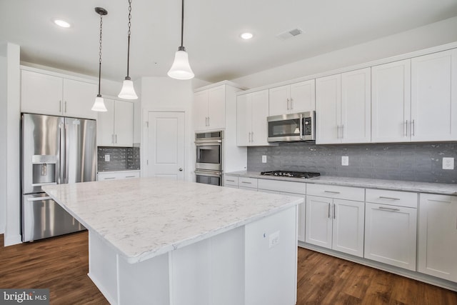 kitchen featuring a center island, dark hardwood / wood-style floors, tasteful backsplash, stainless steel appliances, and white cabinets