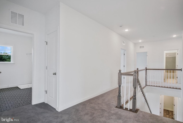 hall featuring dark colored carpet