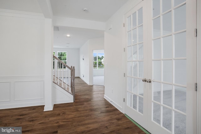 corridor with dark hardwood / wood-style flooring and french doors