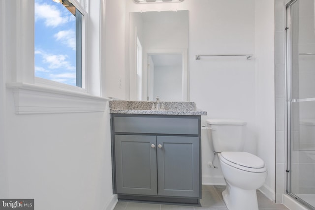 bathroom featuring tile patterned floors, an enclosed shower, vanity, and toilet