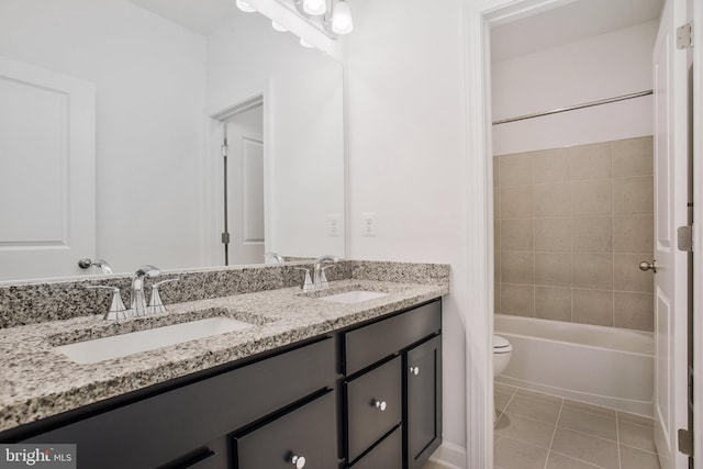 full bathroom featuring tile patterned flooring, vanity, tiled shower / bath combo, and toilet