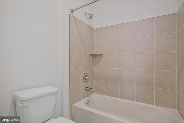 bathroom with tiled shower / bath combo and toilet