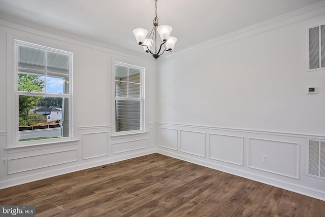 unfurnished dining area with dark hardwood / wood-style flooring, an inviting chandelier, and ornamental molding