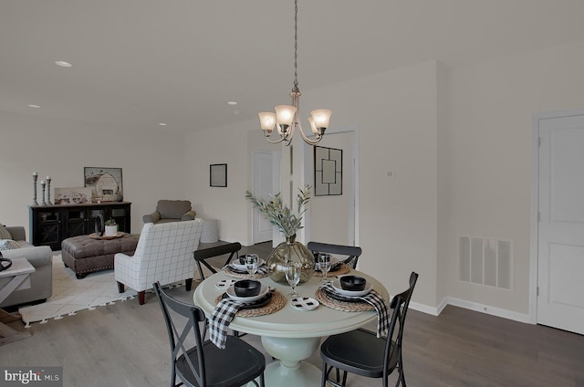 dining area featuring recessed lighting, wood finished floors, visible vents, baseboards, and an inviting chandelier