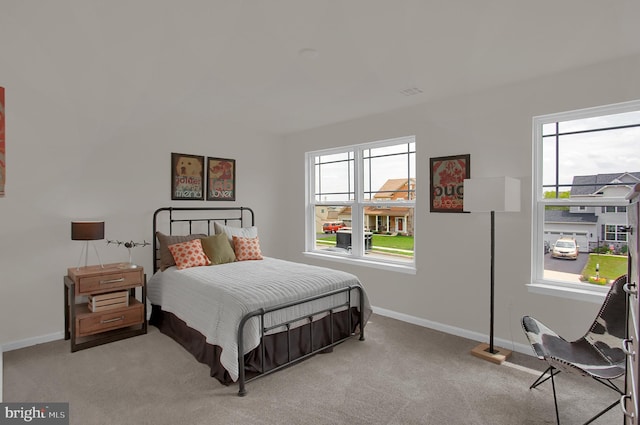 bedroom with light colored carpet and baseboards