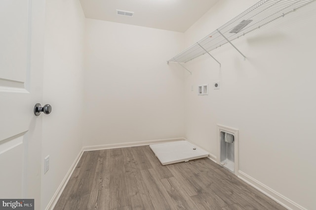 clothes washing area featuring hardwood / wood-style floors, electric dryer hookup, and hookup for a washing machine