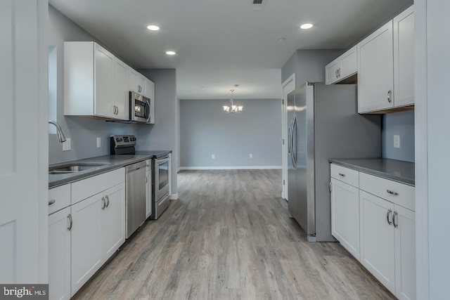 kitchen with sink, an inviting chandelier, light hardwood / wood-style floors, stainless steel appliances, and white cabinets