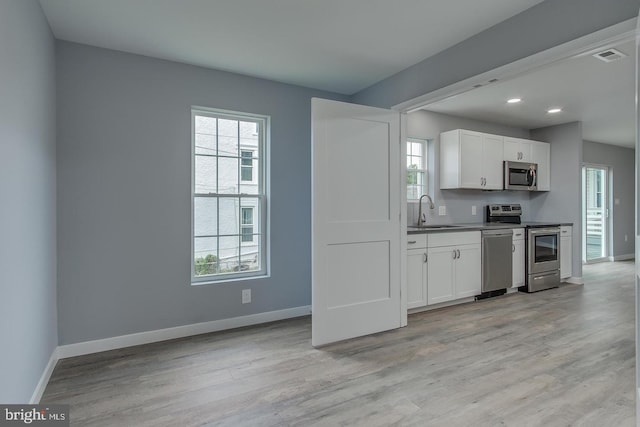 kitchen with stainless steel appliances, light hardwood / wood-style flooring, and plenty of natural light