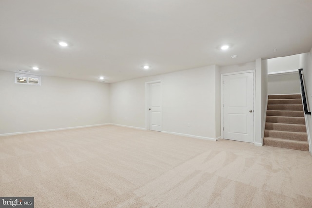 finished basement featuring recessed lighting, light carpet, baseboards, and stairs