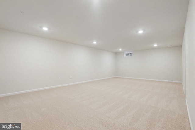 finished below grade area with recessed lighting, light colored carpet, visible vents, and baseboards