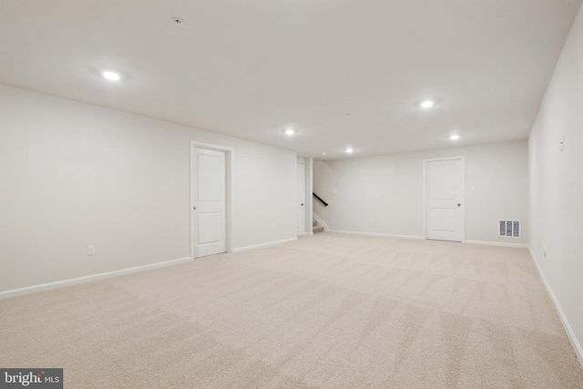 finished below grade area featuring light colored carpet, visible vents, and recessed lighting