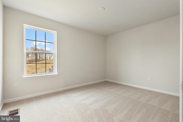 unfurnished room featuring carpet, visible vents, and baseboards