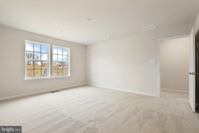 empty room with light carpet, visible vents, and baseboards