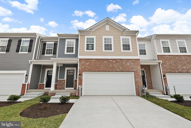 view of property featuring driveway, an attached garage, and brick siding