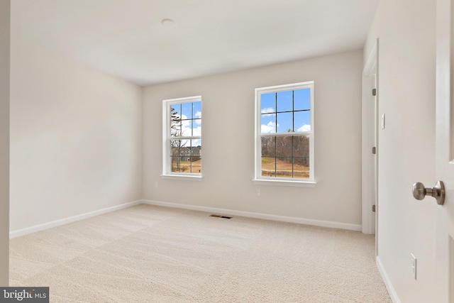 unfurnished room featuring light carpet, visible vents, and baseboards