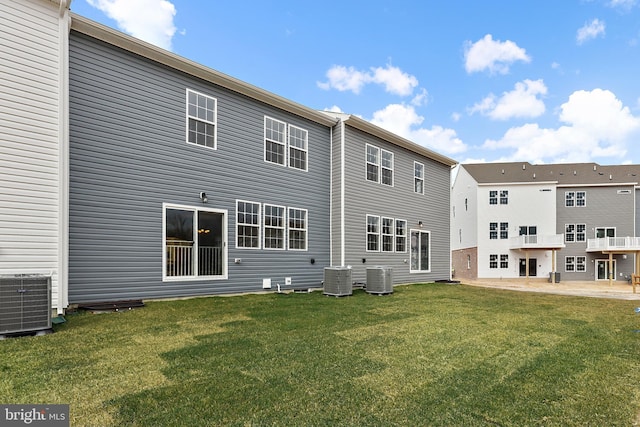 back of property with a yard and central AC unit