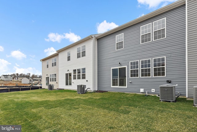 rear view of property with a yard and central AC unit