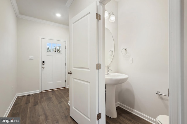 half bathroom featuring ornamental molding, toilet, baseboards, and wood finished floors