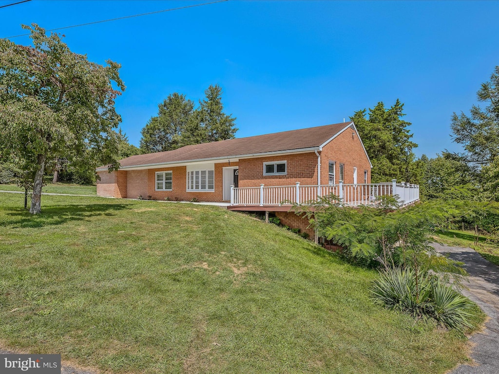 view of front of house with a deck and a front yard