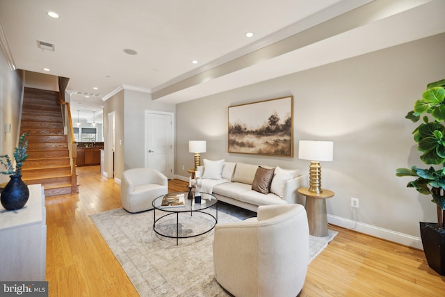 living room featuring ornamental molding and light hardwood / wood-style flooring