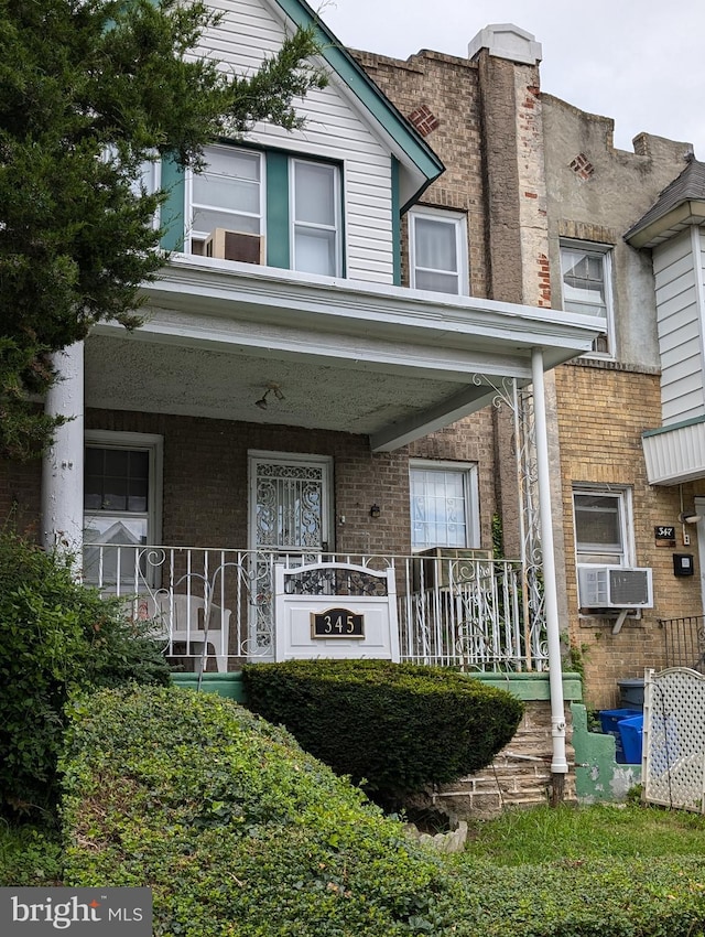 townhome / multi-family property featuring cooling unit and a porch